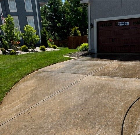 Driveway covered in dirt and algae stains before Elite Pressure Pros cleaning