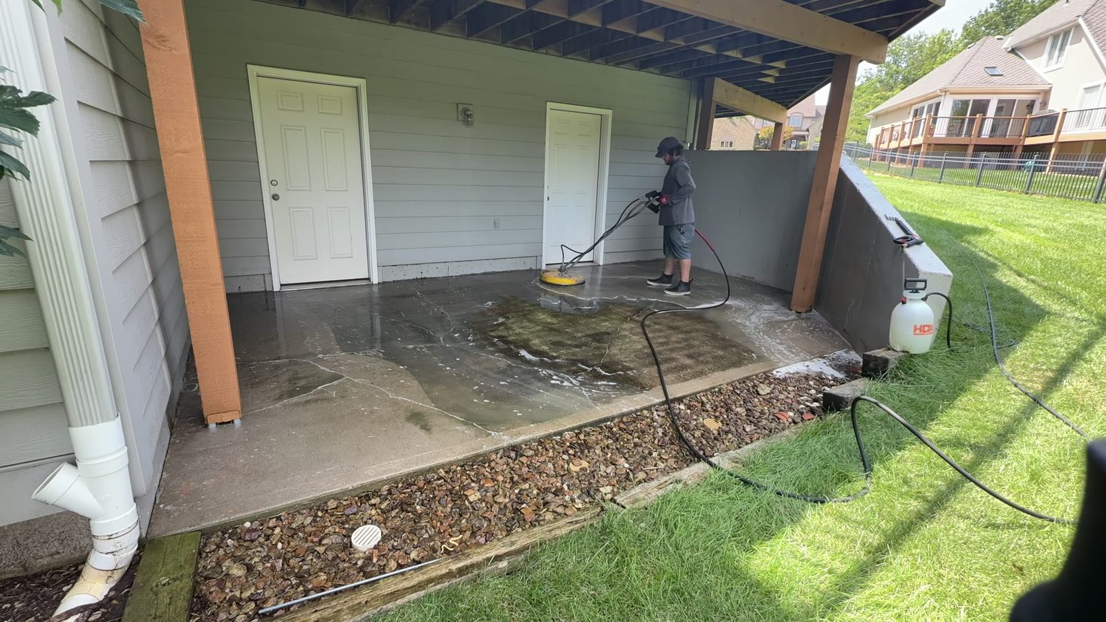 Elite Pressure Pros technician soft washing a covered patio