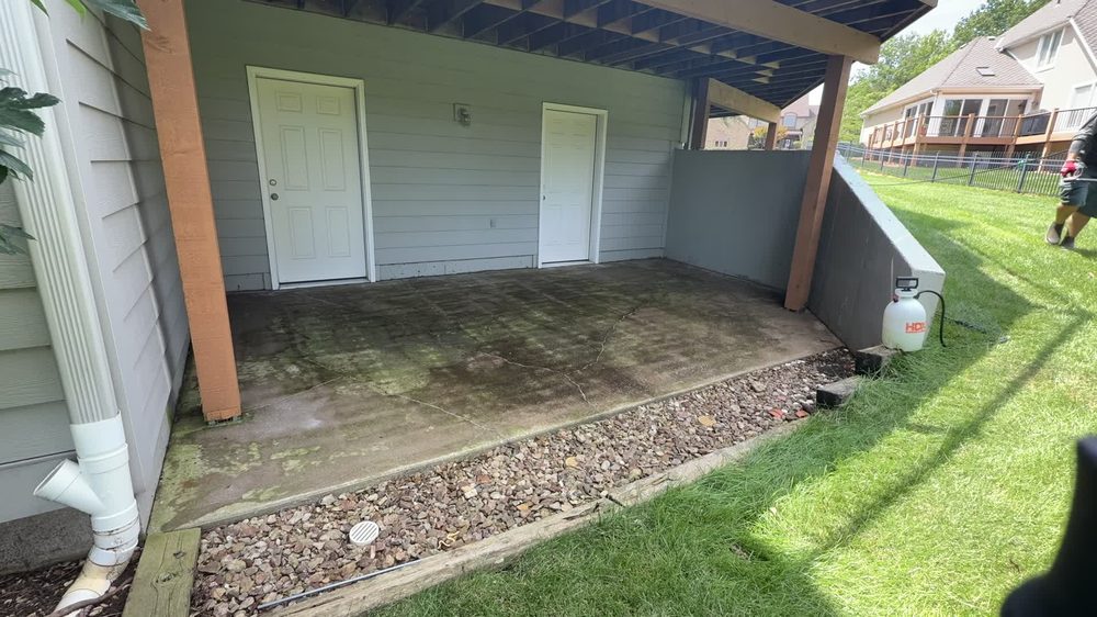 Covered concrete patio with dirt and algae stains before soft washing